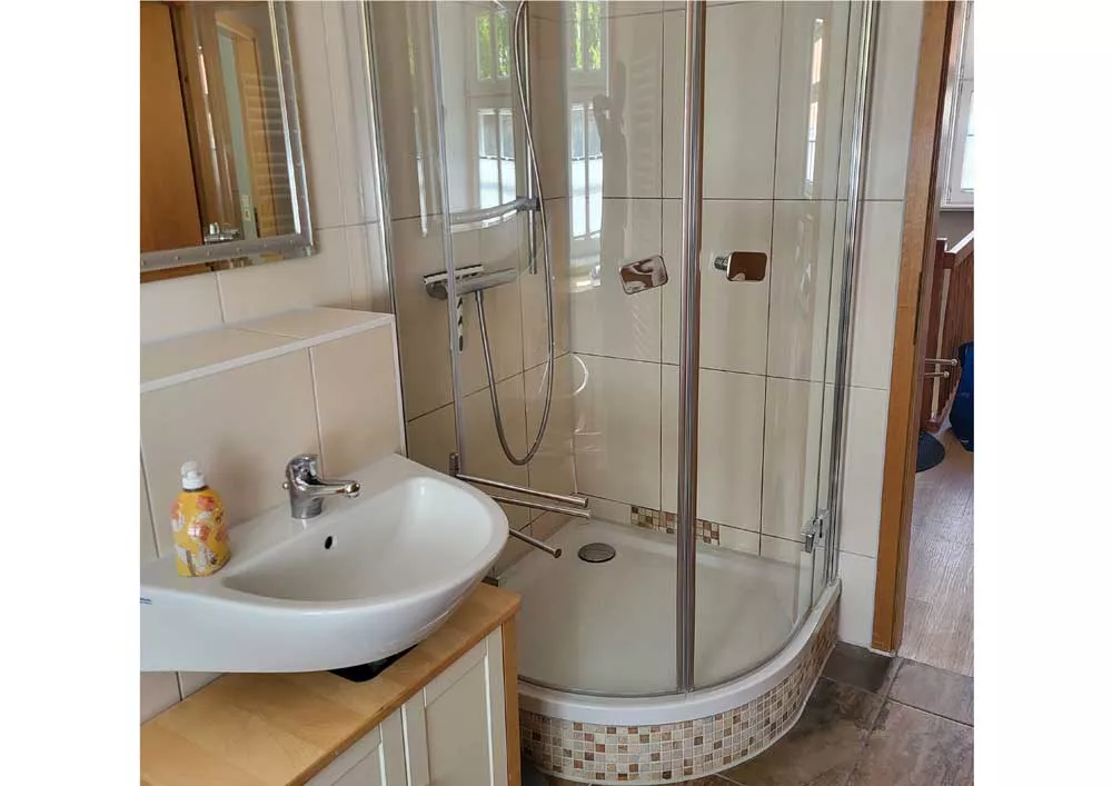 Modernes Badezimmer mit großer bodengleicher Dusche und Waschbecken im Ferienhaus in Neubrandenburg