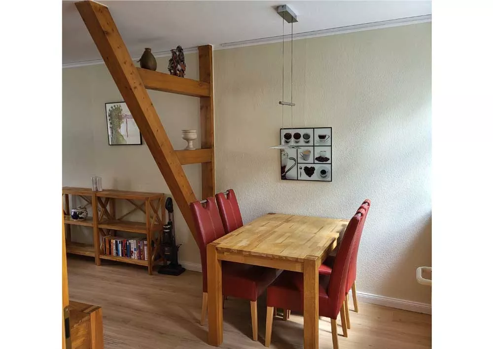 Essbereich mit massivem Holztisch und roten Stühlen im Ferienhaus in Neubrandenburg