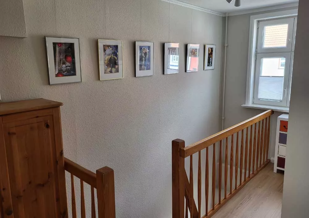 Oberer Treppenhausbereich mit dekorativer Bilderreihe im Ferienhaus in Neubrandenburg