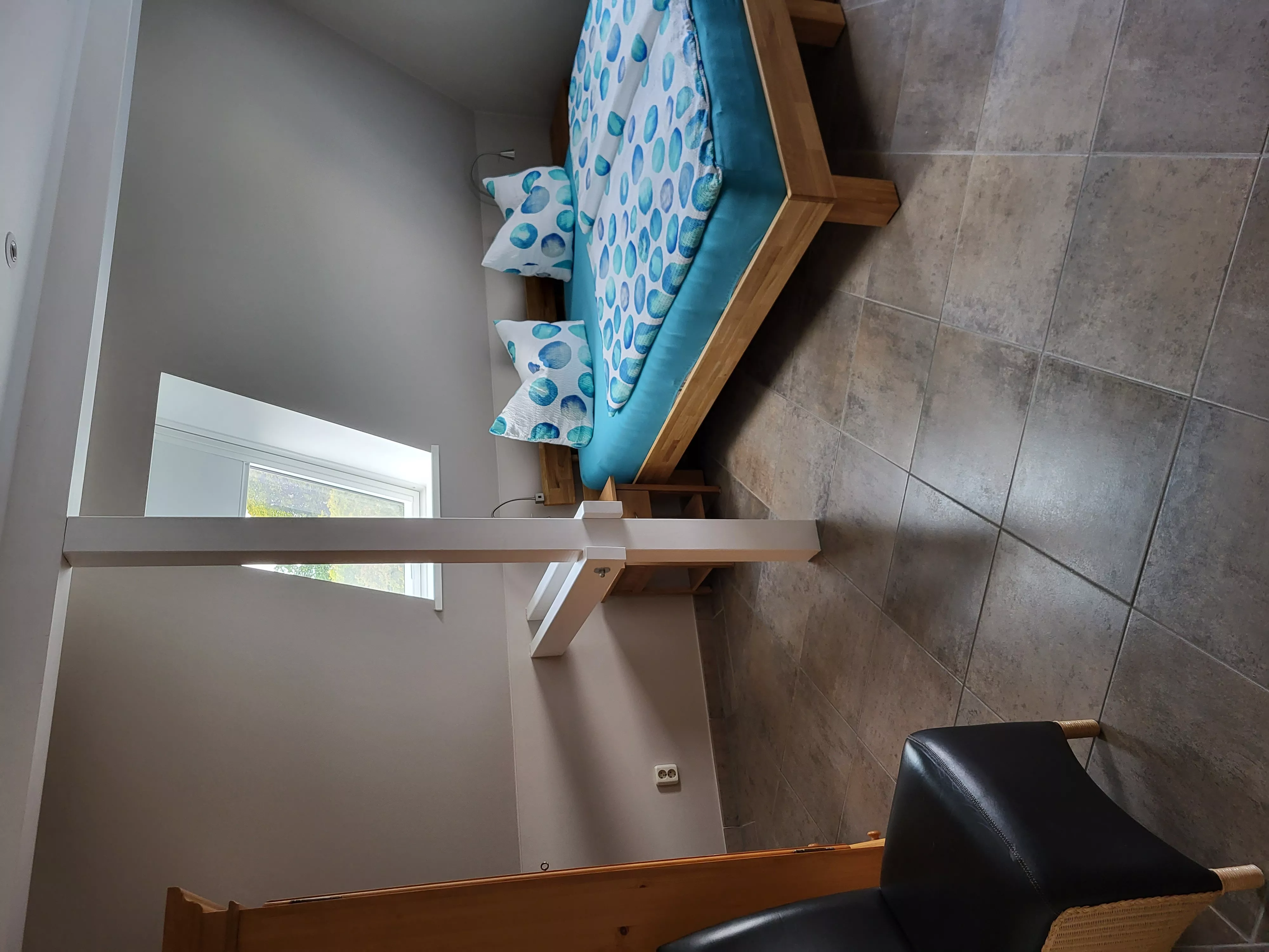 Erstes Schlafzimmer des Loft-Ferienapartments in Waren an der Müritz mit komfortablem Doppelbett und frischer Bettwäsche in beruhigenden Blautönen
